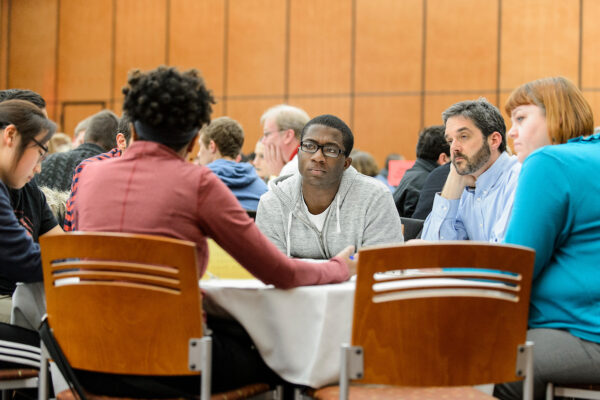 A group of people sitting at a table and discussing