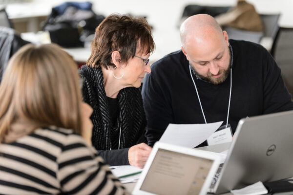 Two people looking at a piece of paper and discussing