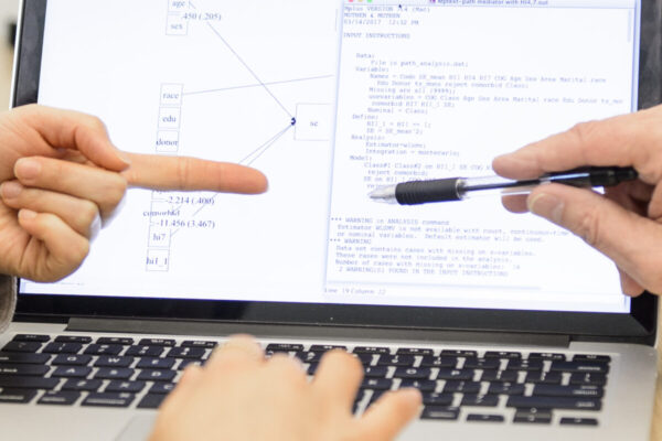 Close-up of staff working around shared laptop screen