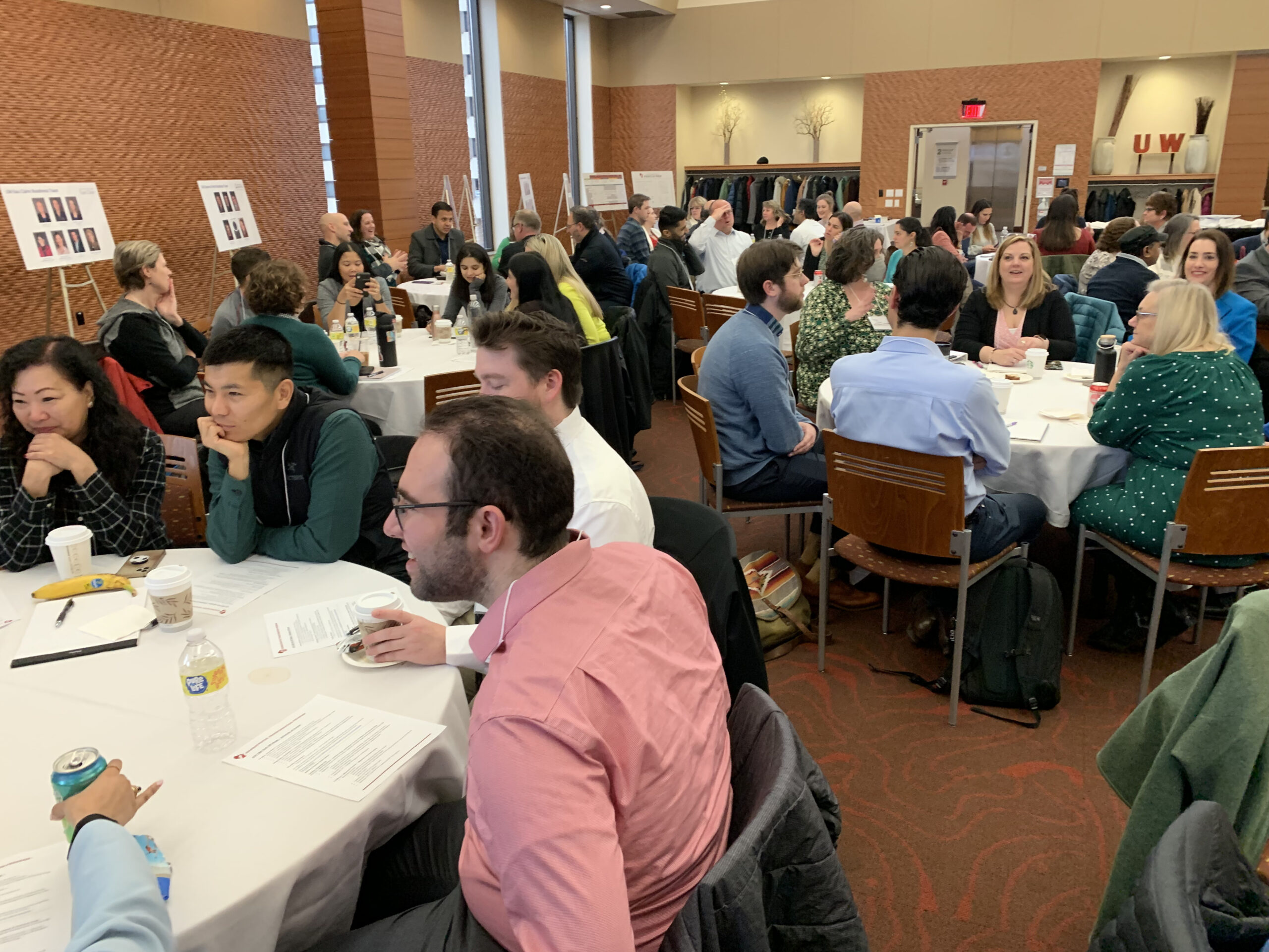 Photograph of a group of people engaging in conversation around tables