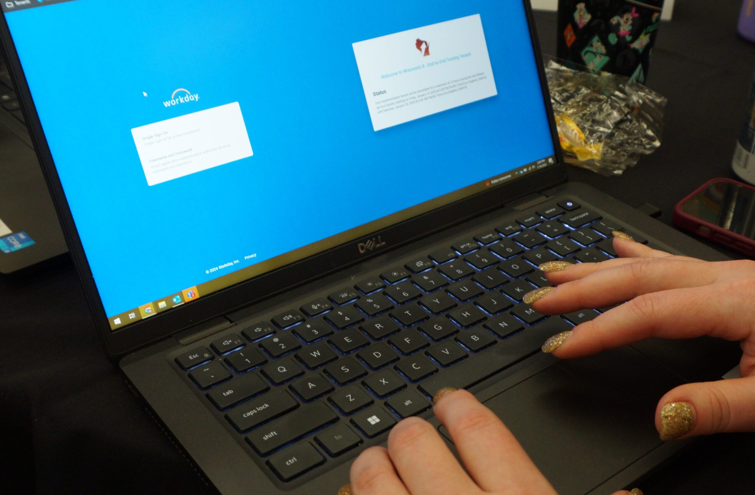 Photograph of the Workday login screen with hands typing on a laptop keyboard.