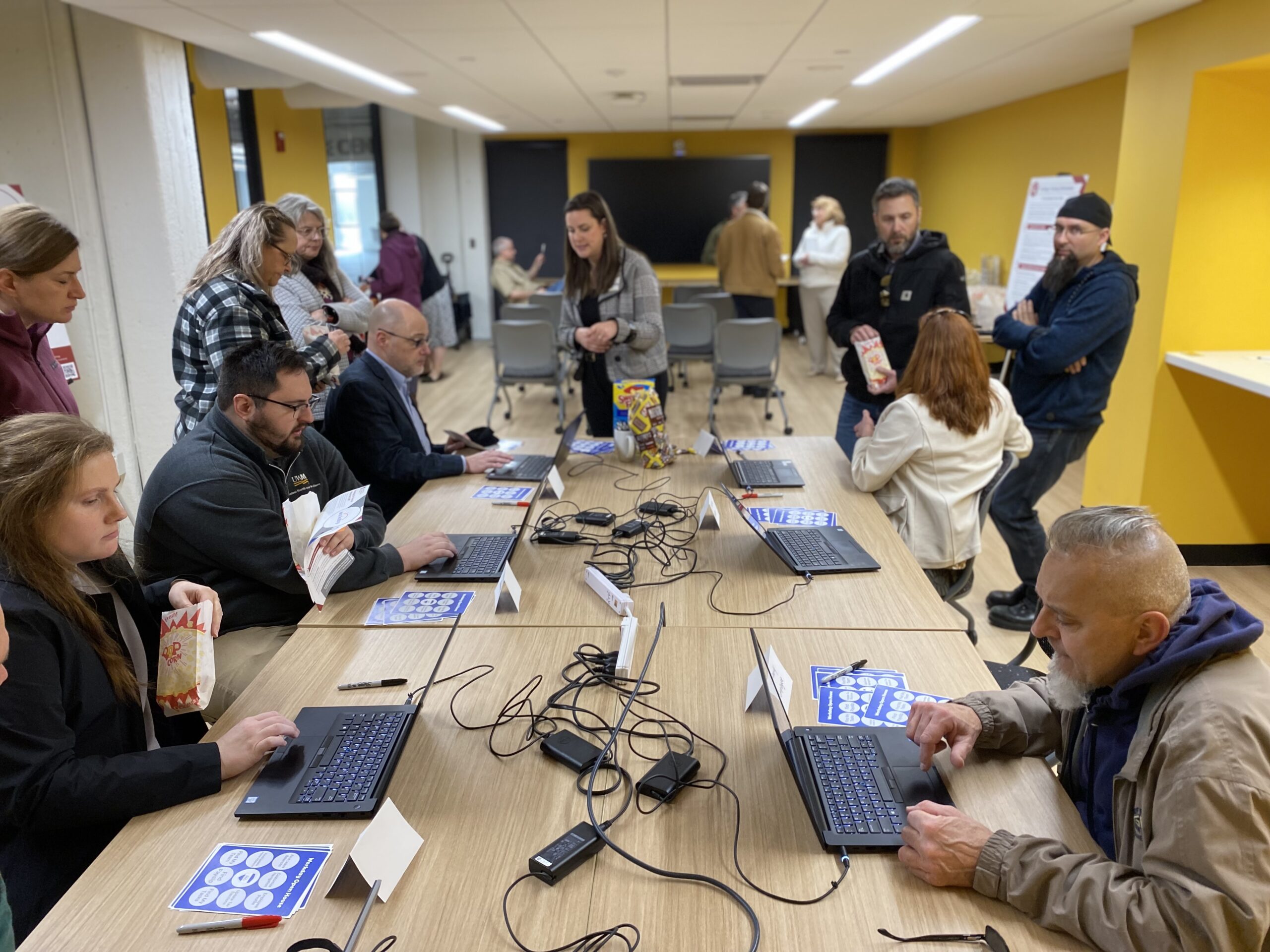 UW-Milwaukee staff type on laptops in a large conference room.